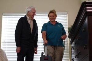 ER Senior Management | Associate vacuuming for resident